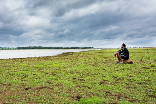 A man sitting enjoying the ocean view in running gear